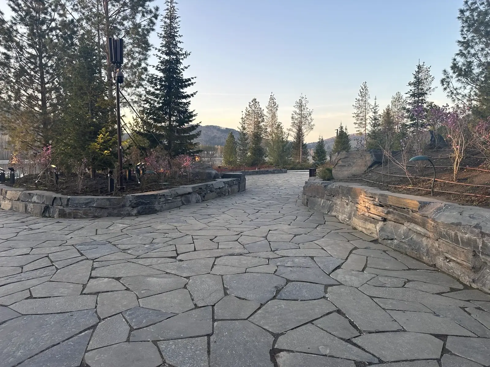 An area paved with shungite slabs, with retaining walls and plantings